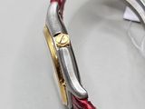 a close up of a watch on a white surface with a red strap