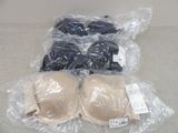 three pairs of bras are wrapped in plastic bags on a table