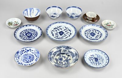 Plusieurs assiettes et bols bleus et blancs sont disposés en cercle