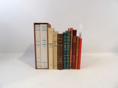 several books are stacked on top of each other on a white surface