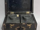 a black and gold box with two cups inside of it