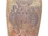 a silver spoon with a crest on it on a white surface