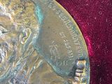 a silver medal with a picture of a man on it