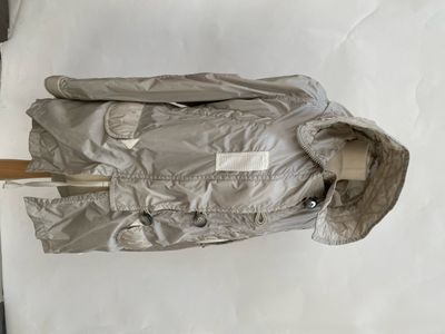 a silver jacket with a wooden handle on a white surface