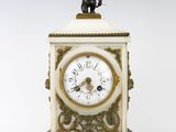 une petite horloge surmontée d'une statue
