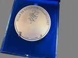 silver medal in a blue box on a gray surface
