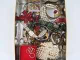 une boîte remplie de bijoux assortis posée sur une surface blanche