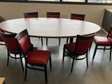 une table ronde entourée de six chaises rouges