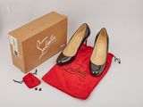 pair of women ' s black shoes in a red bag next to a pair of red shoes