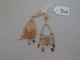deux paires de boucles d'oreilles dorées sur fond blanc