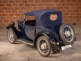 a small blue car parked in front of a brick wall