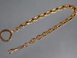 a close up of a gold chain with a ring on it