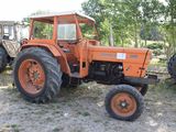 two tractors that are parked in the dirt