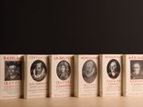 cinq livres posés sur une table avec un fond noir et un fond noir