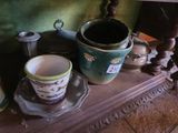 de nombreuses tasses et soucoupes posées sur une étagère dans une pièce