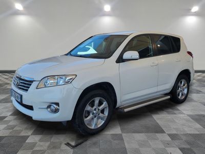 the white toyota rav is parked on a checkered tile floor