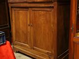 un meuble en bois avec une porte en verre dans une pièce