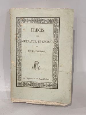 an old book sitting on top of a table next to a white wall