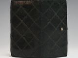 a black leather wallet with a gold button on the front