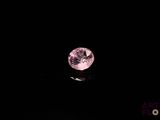 gros plan d'un diamant rose sur une surface noire