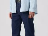 the man is wearing a light blue shirt and blue jeans