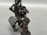 figurine en bronze représentant un homme avec un oiseau sur l'épaule