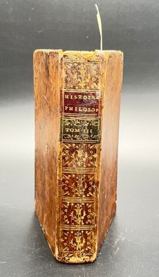 an old book sitting on top of a table next to a candle