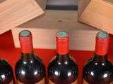 several bottles of wine are lined up on a red table