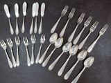 a lot of forks and spoons that are on the table