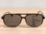 sunglasses on a wooden table with a white wall in the background