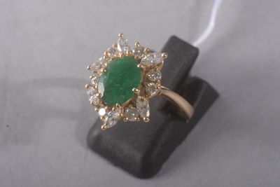 gros plan d'une bague avec une pierre verte entourée de diamants