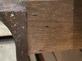 a close up of a wooden bench with a spider web on it