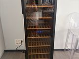 someone taking a picture of a wine cooler in a room