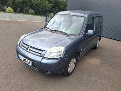 une petite camionnette bleue garée devant un immeuble
