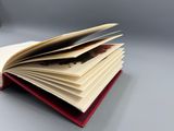un livre ouvert, surmonté d'une plume, posé sur une table