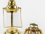 an antique brass oil lamp with a glass cover and a brass faucet