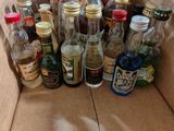 many bottles of liquor in a box on the floor
