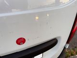 a red sticker on the back of a white car