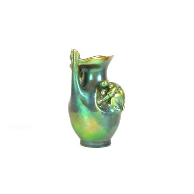un vase vert posé sur une surface blanche