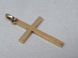pendentif en forme de croix plaqué or sur fond blanc