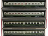 six trains miniatures sont empilés dans une boîte posée sur une surface blanche