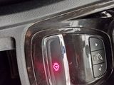 a close up of a car ' s dashboard with a red button