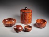 three wooden bowls and a wooden container on a gray surface