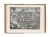 an old book with a drawing of a city in the middle of it