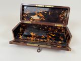 a small tortoise shell box with a key in it