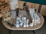 une table sur laquelle sont posés de nombreux objets en verre et des vases