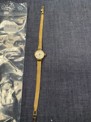 une photo d'une montre posée sur une table, à côté d'un sac en plastique