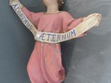 une figurine représentant une femme tenant une banderole