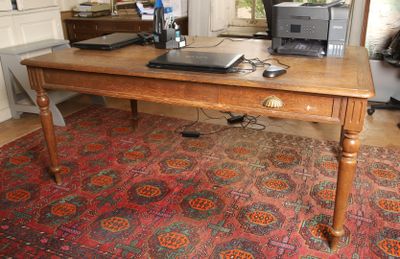 une table en bois sur laquelle est posé un ordinateur portable