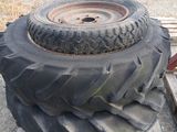 un gros pneu posé sur une palette, à côté d'un tas de pneus